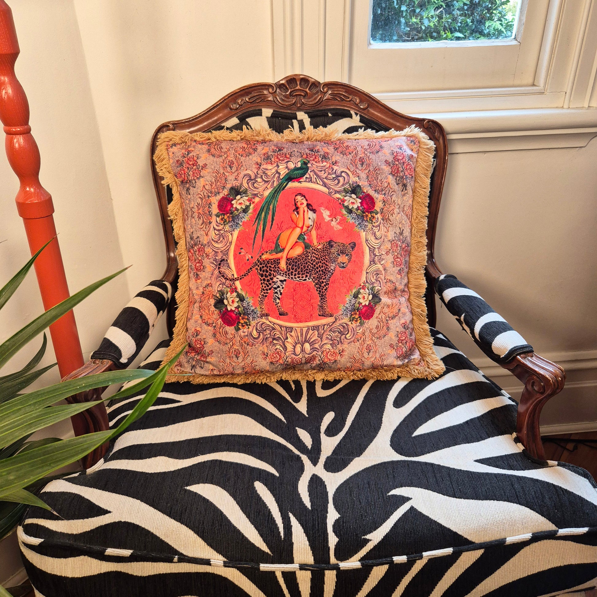 Queen K Alice vintage pin-up cushion with fringe trim featuring a colorful retro design on a patterned chair