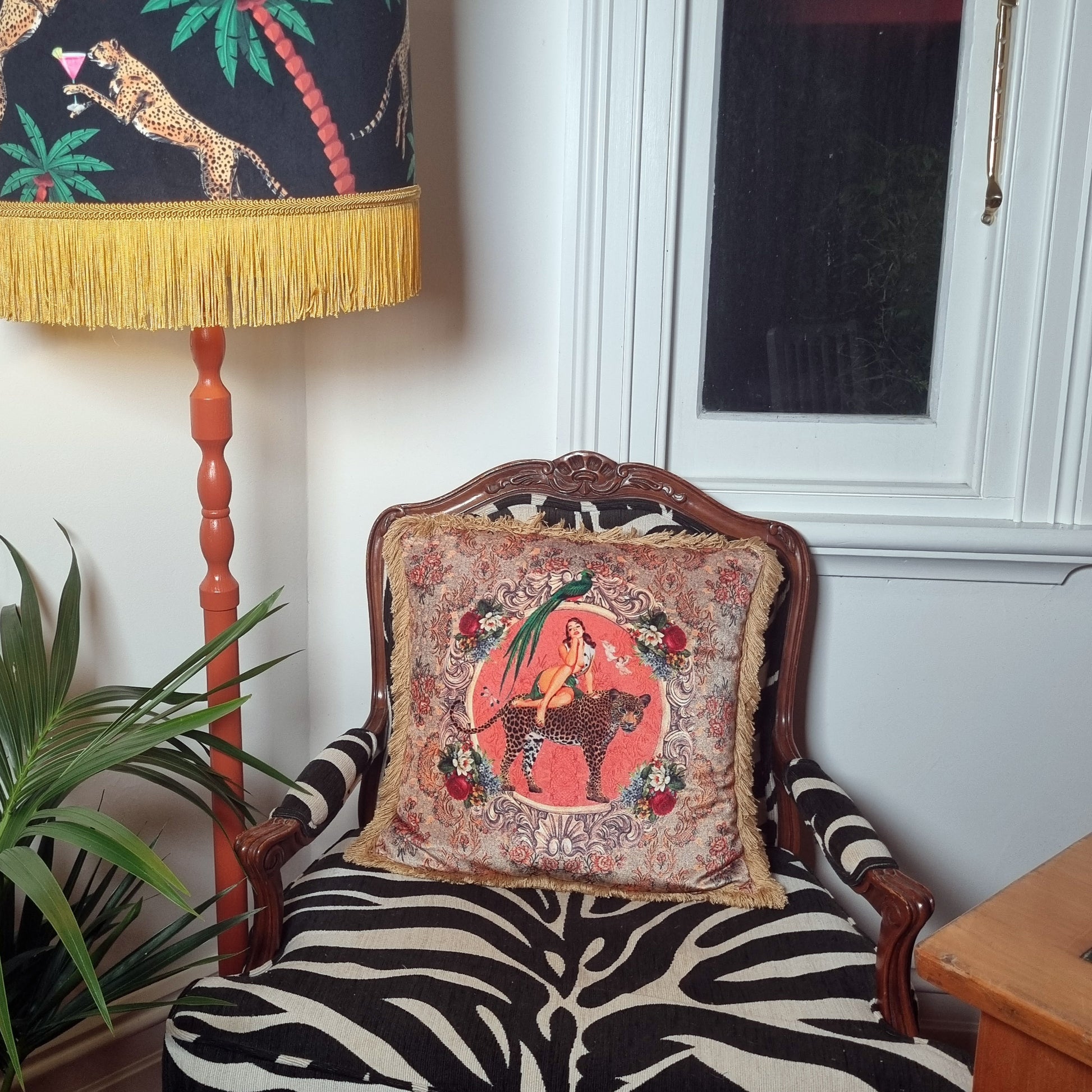 Queen K Alice vintage pin-up cushion with fringe on patterned armchair in cozy living room