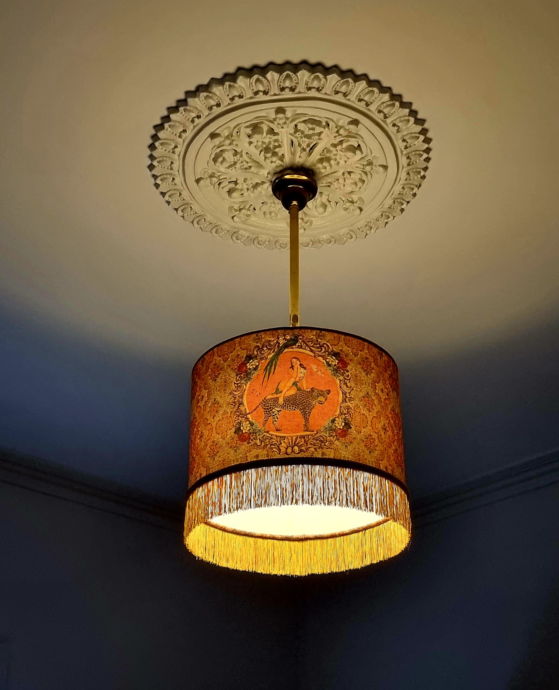 Queen K Alice Vintage Tassel Drum Lamp shade with ornate fringe and warm golden pattern hanging from ceiling