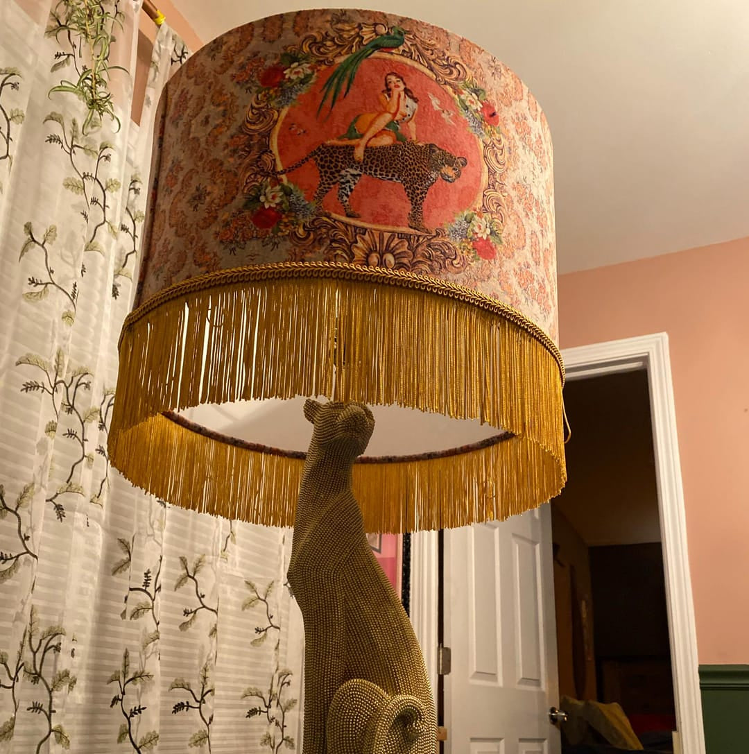 Alice Vintage Tassel Drum Lamp shade with fringed edges and decorative print on a lamp base