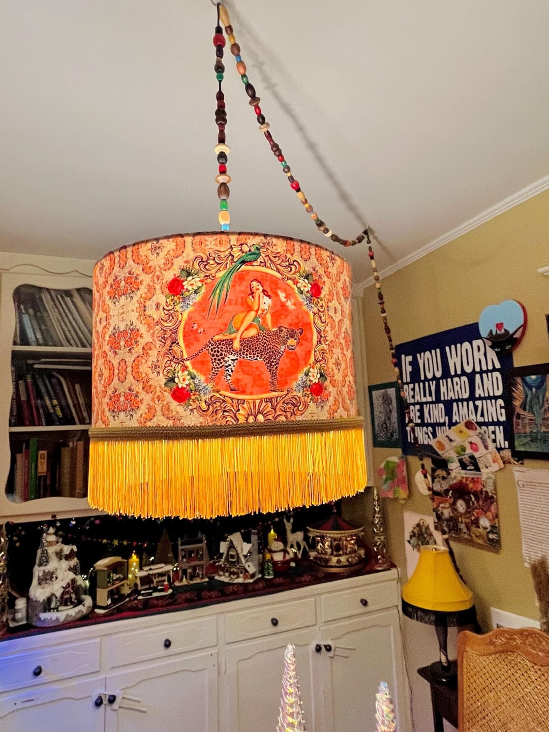 Alice Vintage Tassel Drum Lamp shade with orange floral print and yellow fringe hanging in cozy room