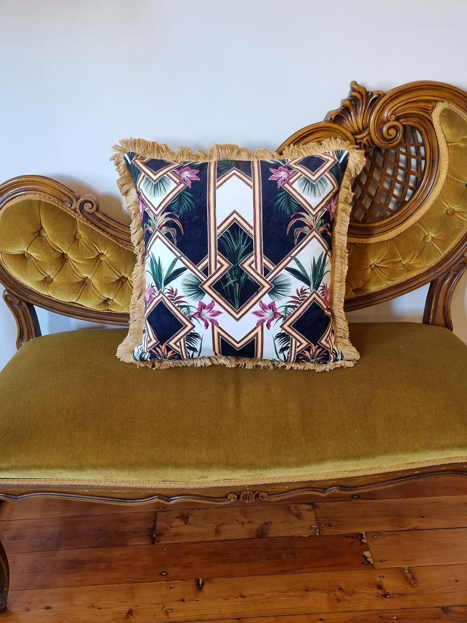 Queen K art deco cushion with geometric and floral pattern on vintage mustard velvet sofa