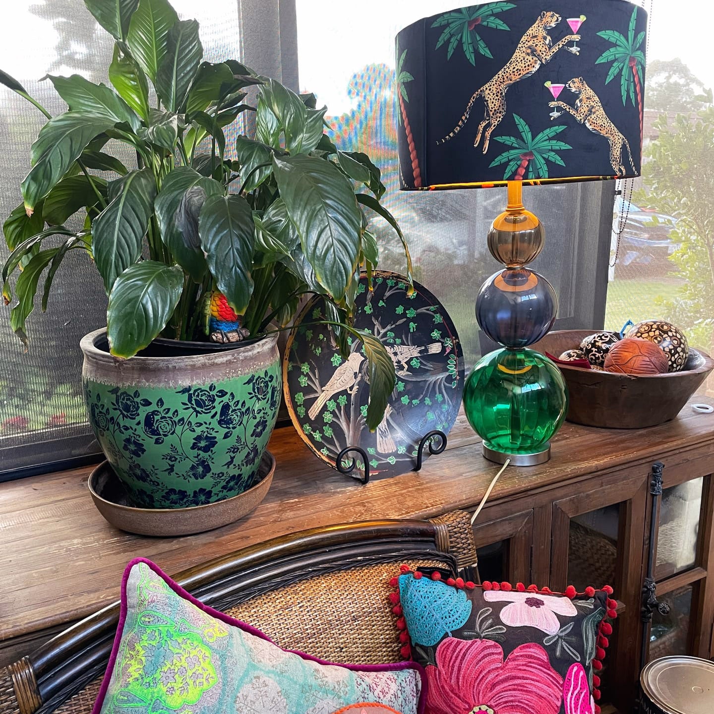 Cocktail Cheetah Drum Lampshade Black with colorful leopard print and palm leaves on a decorative table lamp