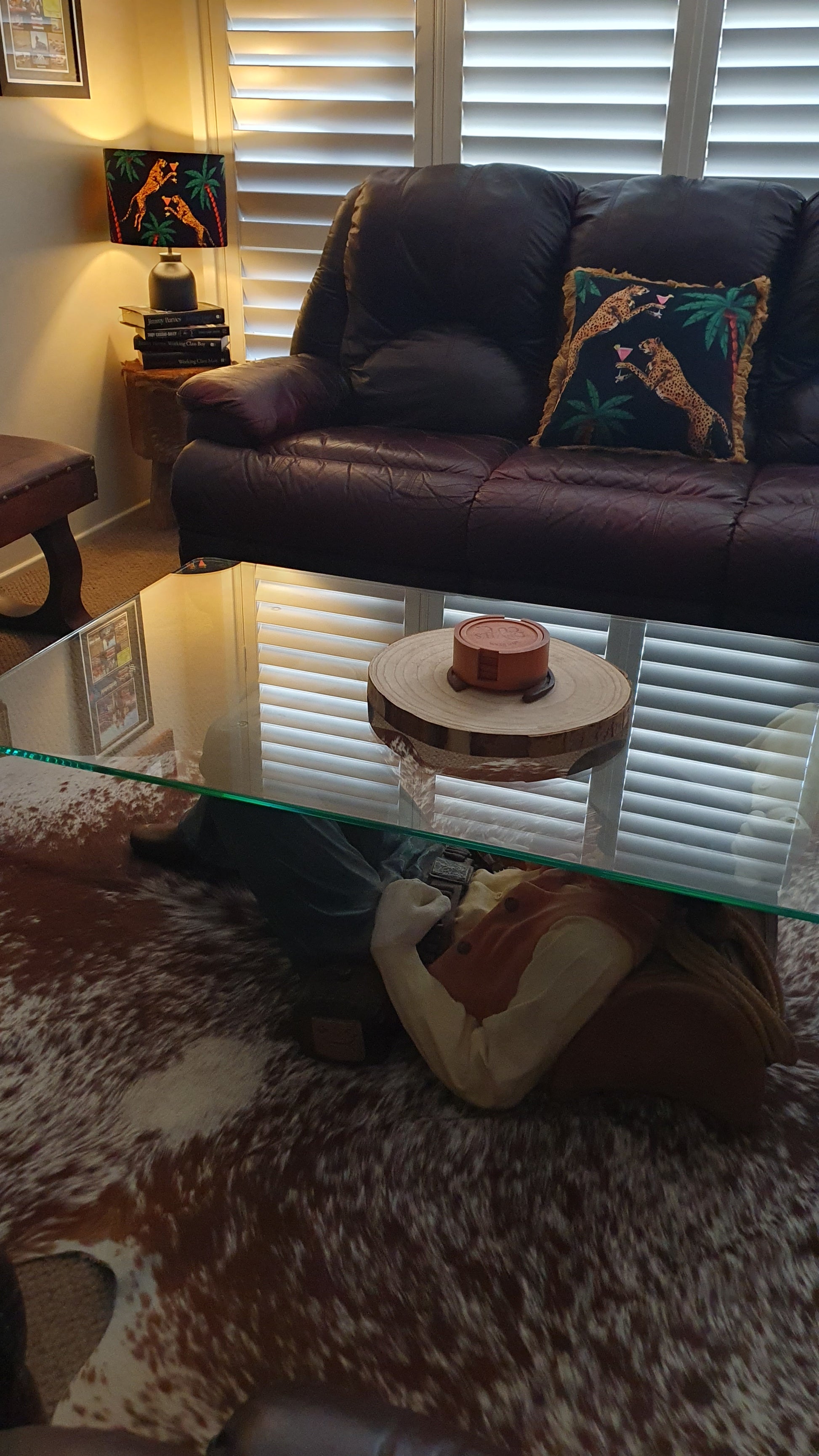 Queen K Cocktail Cheetah print decorative cushion on dark leather sofa in cozy living room