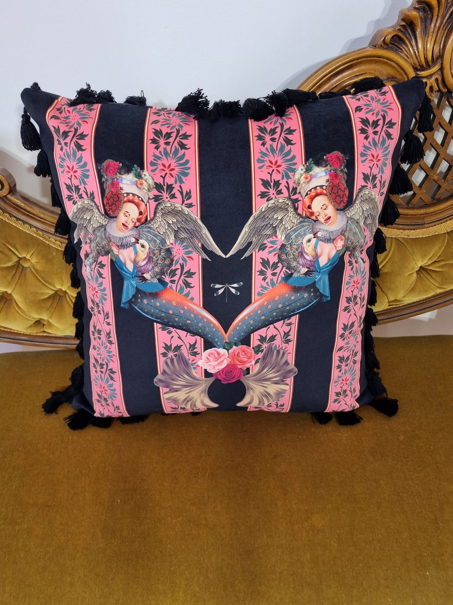 Queen K handmade mermaid pink cushion with detailed mermaid design and black tassels on a gold velvet chair
