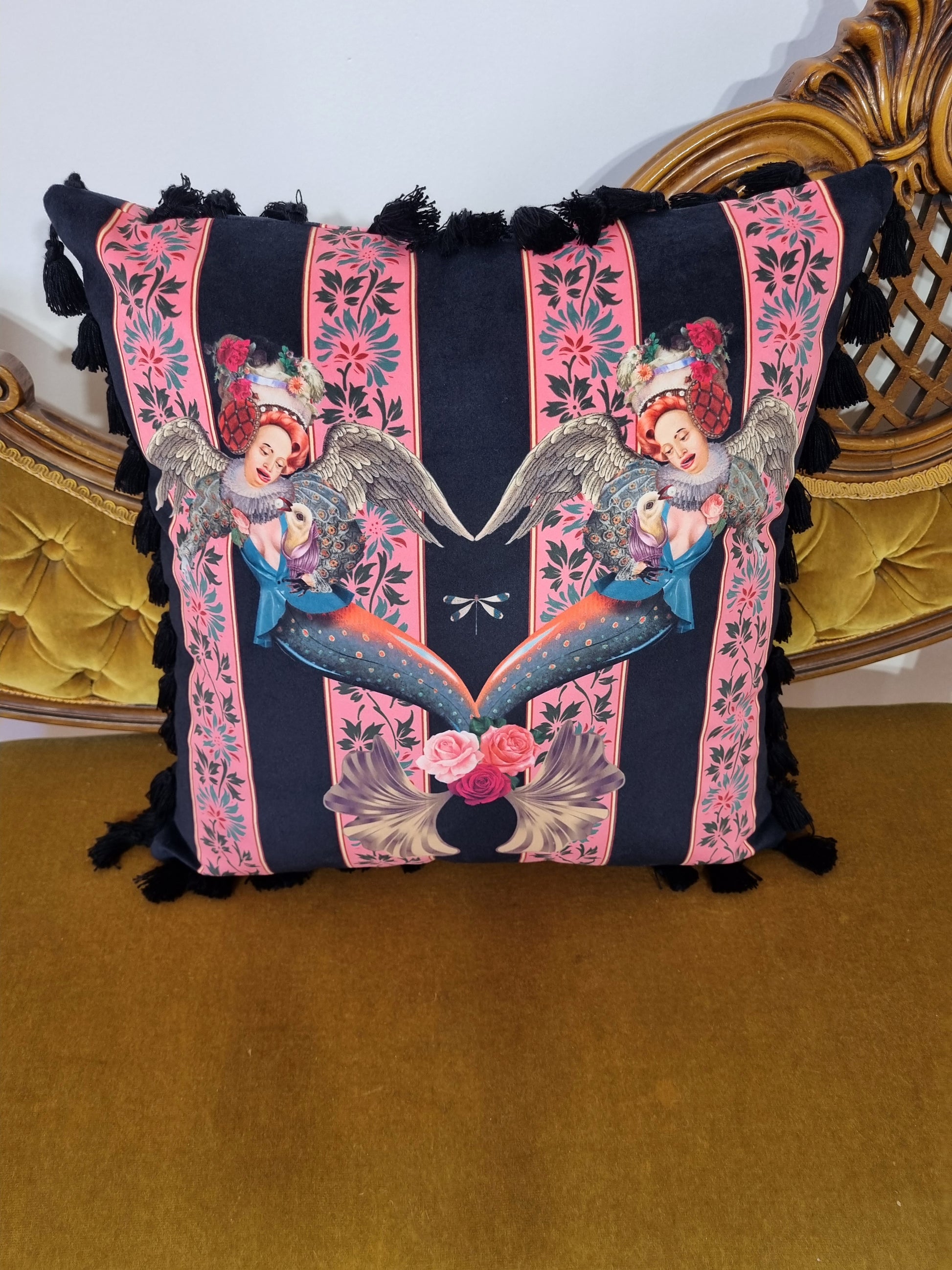 Queen K handmade mermaid pink cushion with detailed mermaid design and black tassels on a gold velvet chair