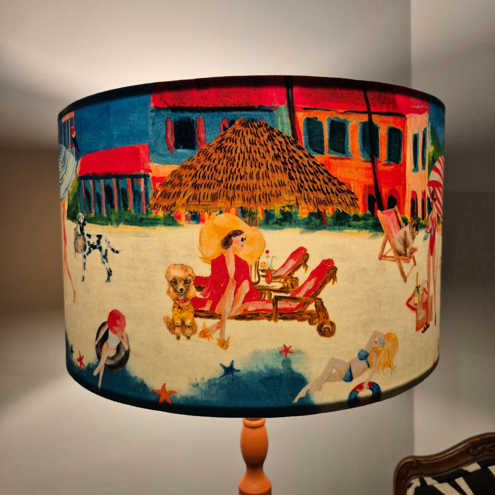 Queen K Riviera Drum Lampshade with colorful beach scene and fringed detail on lamp base