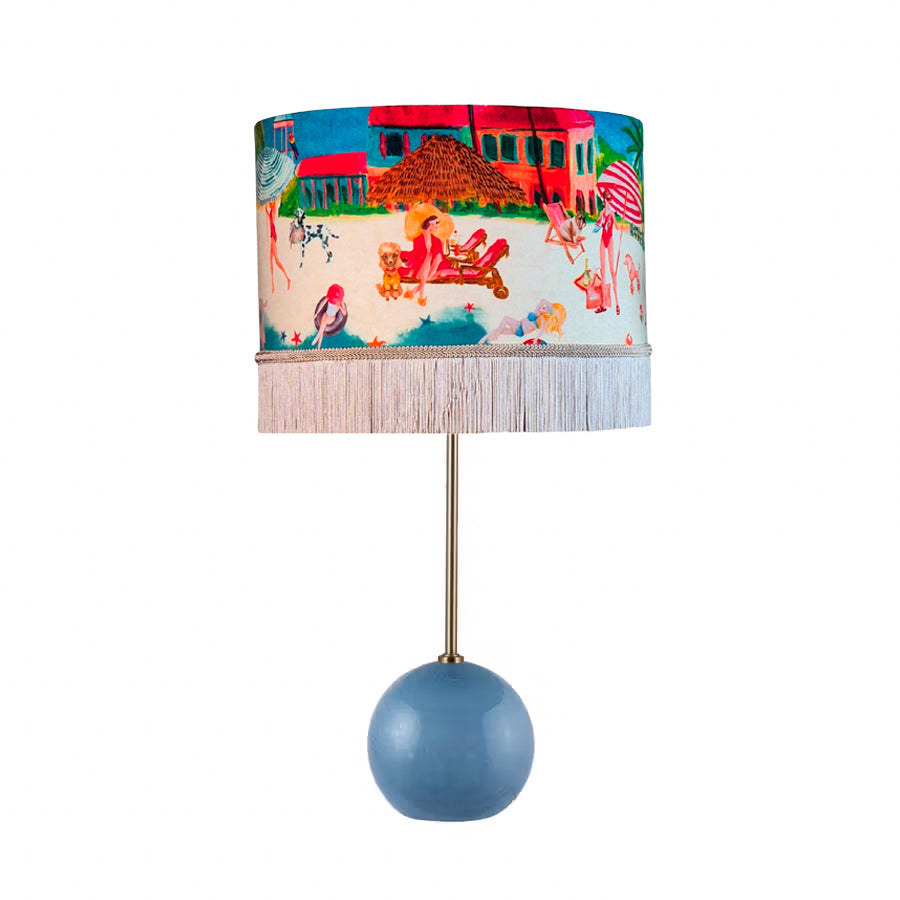 Queen K Riviera Fringed Drum Lampshade with colorful beach scene and white fringe on lamp