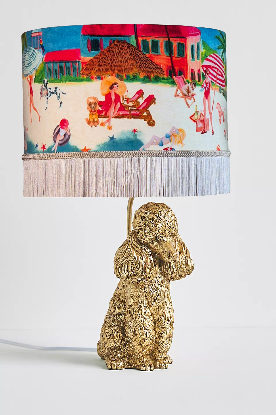 Queen K Riviera Fringed Drum Lampshade with colorful beach scene on dog-shaped gold lamp base
