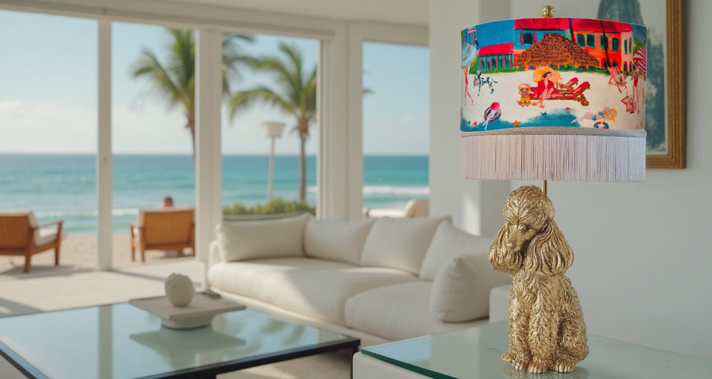Queen K Riviera Fringed Drum Lampshade with colorful beach scene and white fringe on table lamp