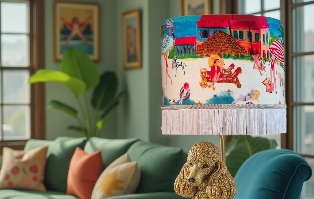 Queen K Riviera Fringed Drum Lampshade with colorful beach scene and white fringe on decorative lamp