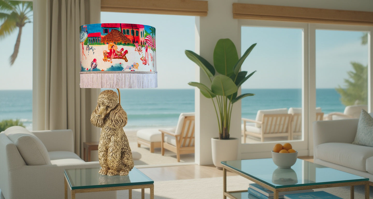 Queen K Riviera Fringed Drum Lampshade with colorful beach design on poodle lamp base in coastal living room