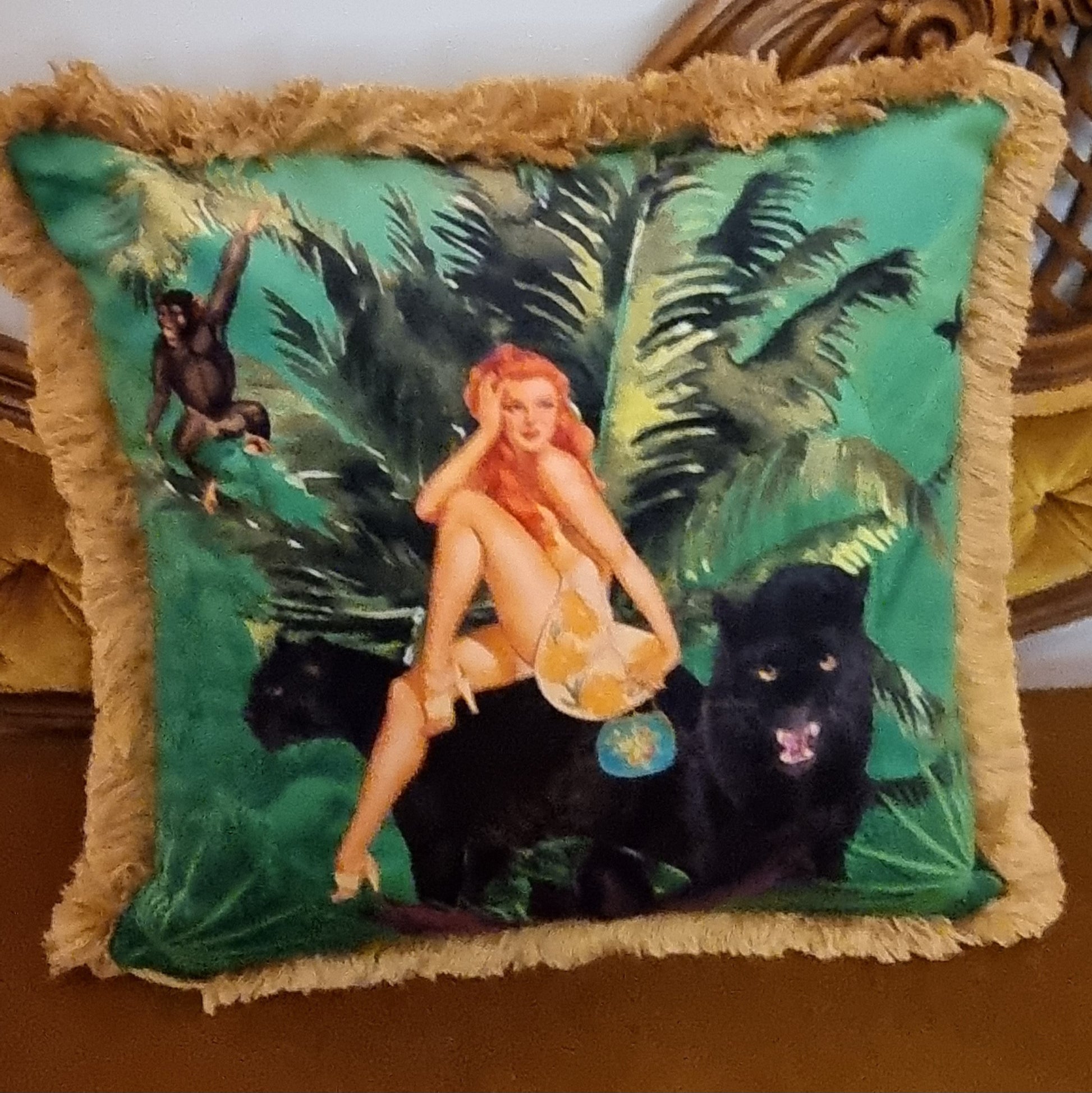 Queen K decorative cushion with jungle scene featuring woman, monkey, and black panthers with fringe border