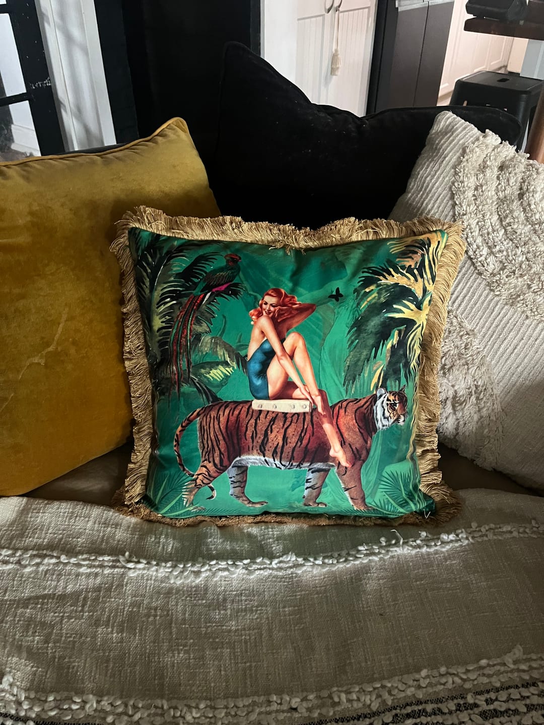 Queen K decorative cushion with fringed edges featuring a woman sitting on a tiger design