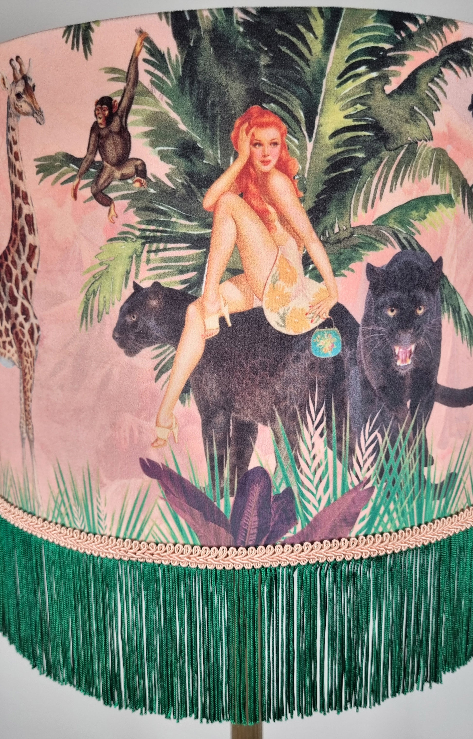 Queen K Jungle Walk Pink Fringed Drum Lampshade featuring jungle animals and a woman with green fringe trim