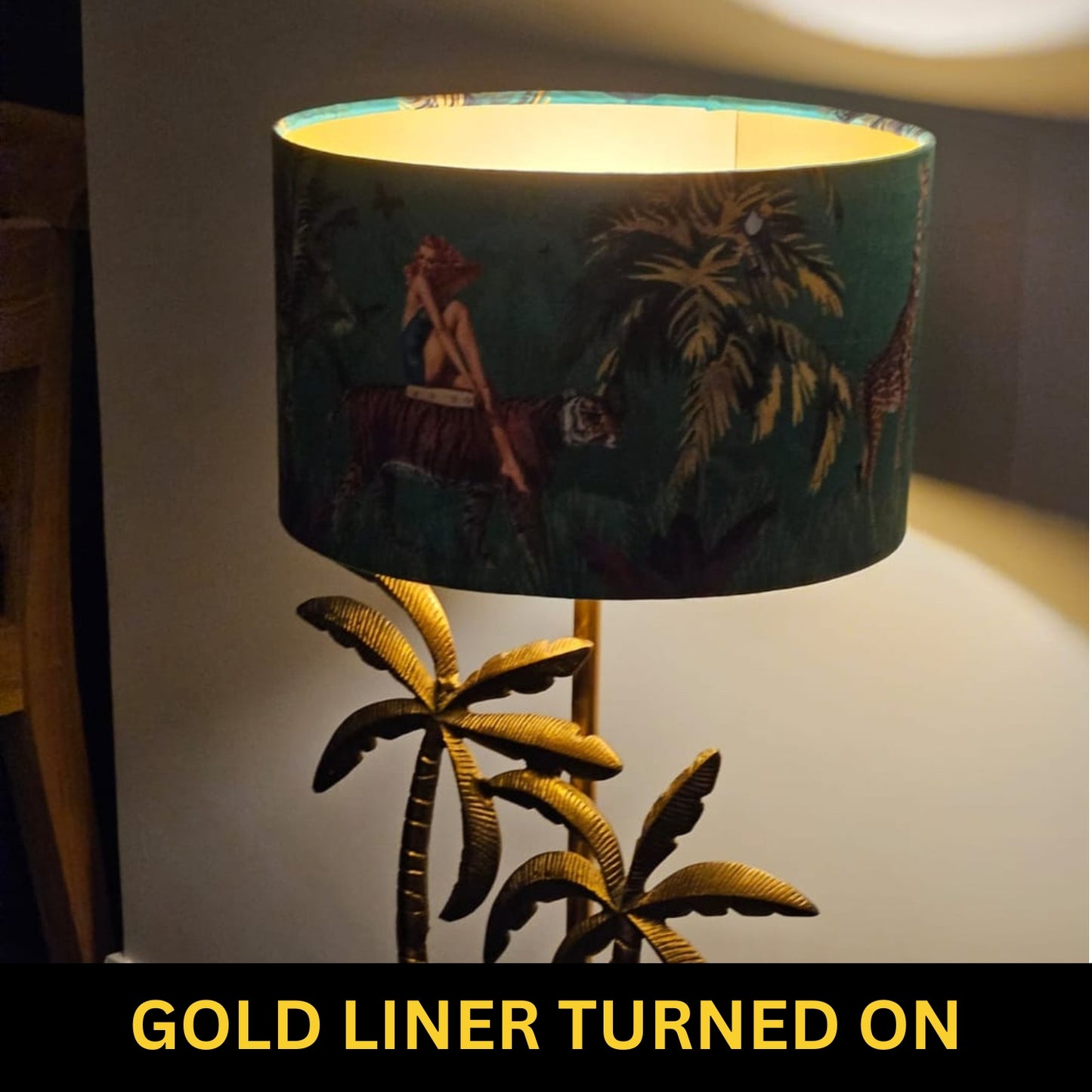 Queen K Jungle Walk Pink Fringed Drum Lampshade with gold liner turned on and tropical design