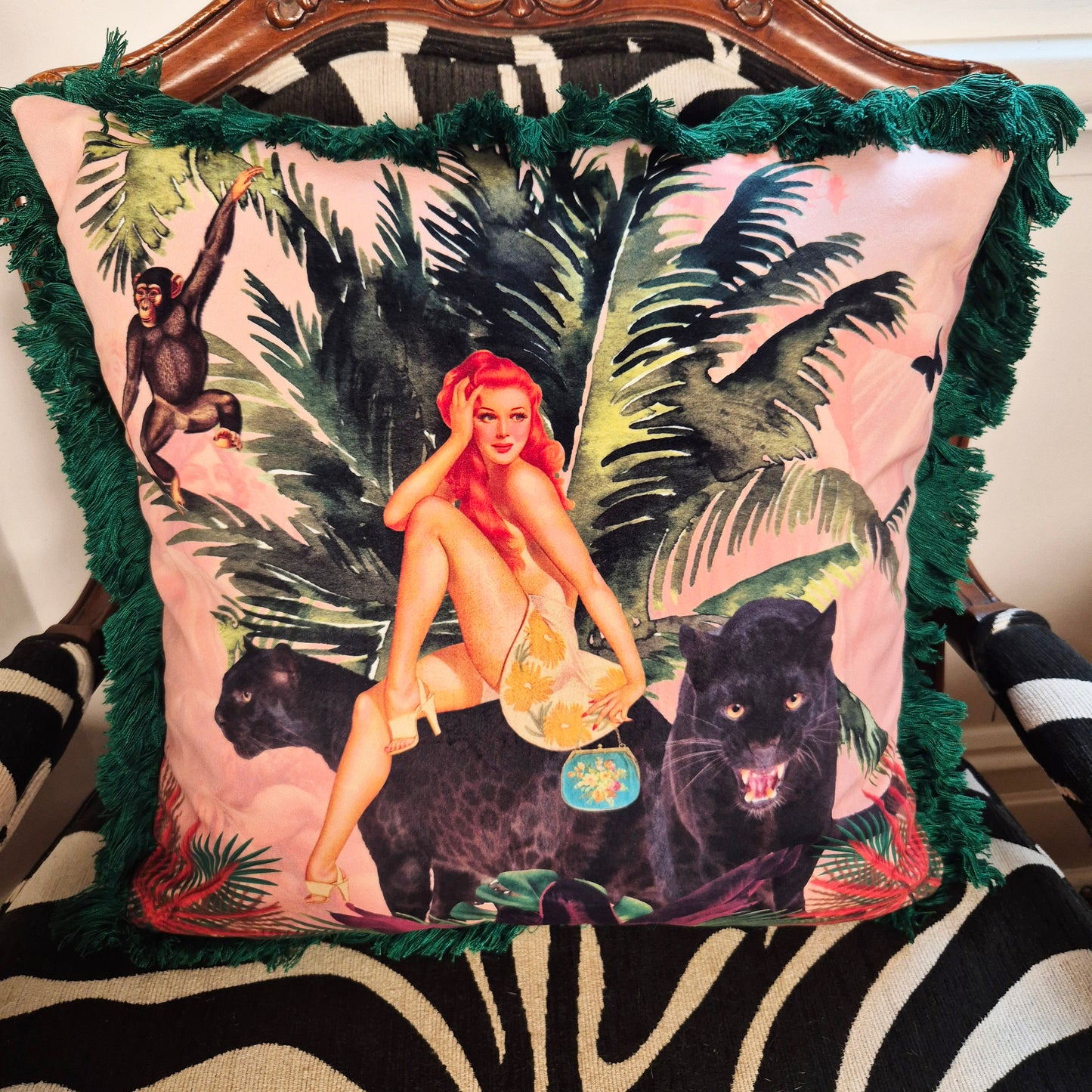 Queen K handmade jungle print cushion featuring a woman with red hair sitting on black panthers with green leafy background